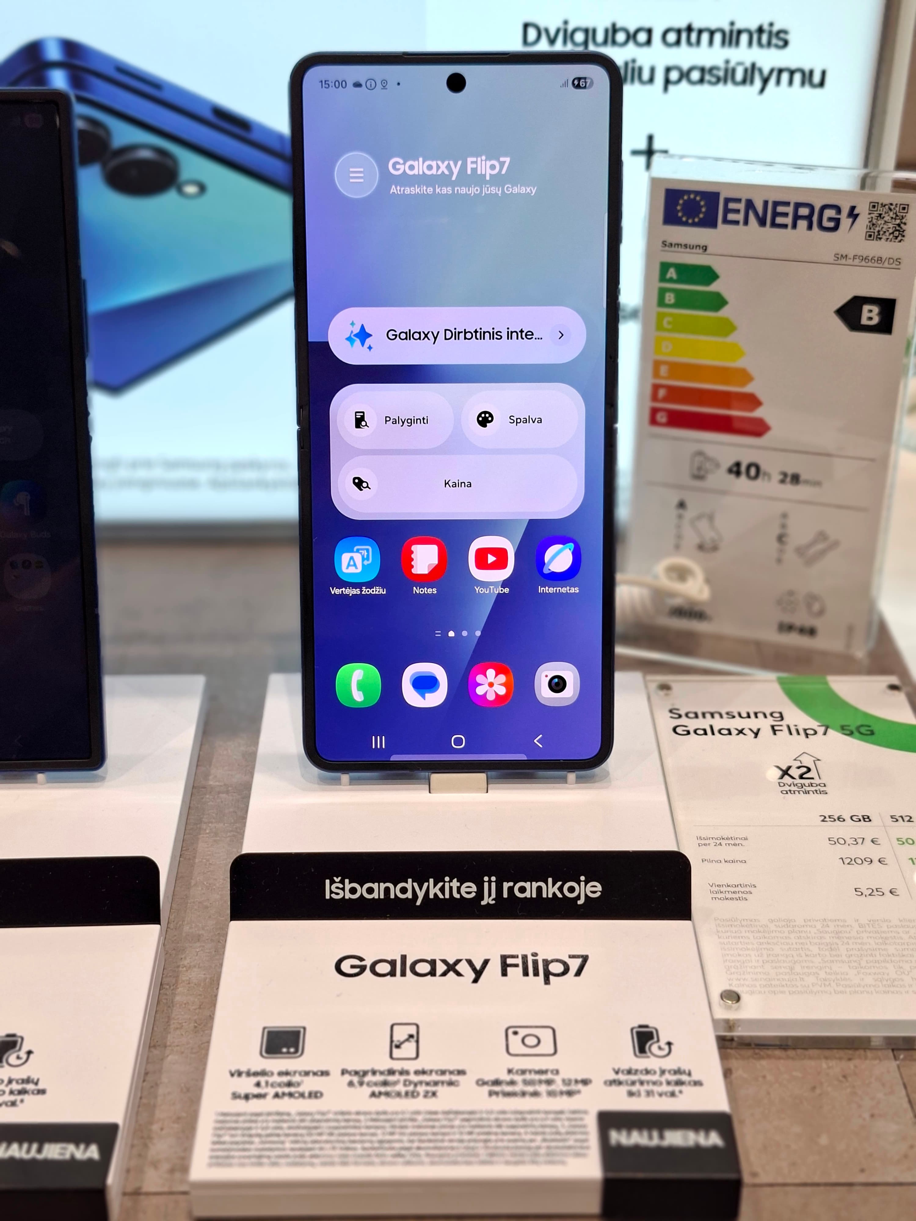 A Samsung Galaxy Z Flip 7 handset and archive display labels in a Lithuanian store