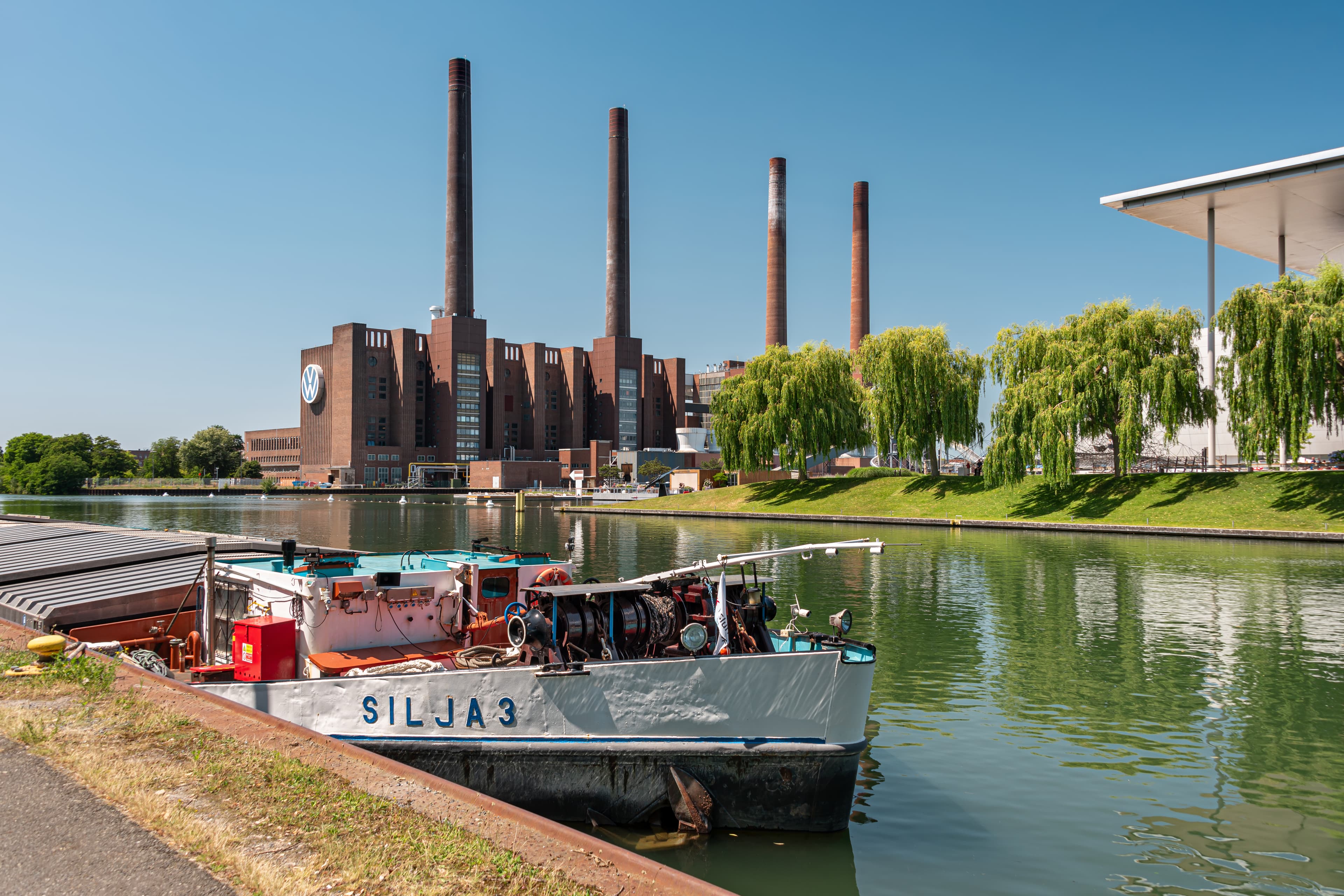 Volkswagen’s brick industrial buildings and power-station chimneys beside the water in Wolfsburg, Germany.