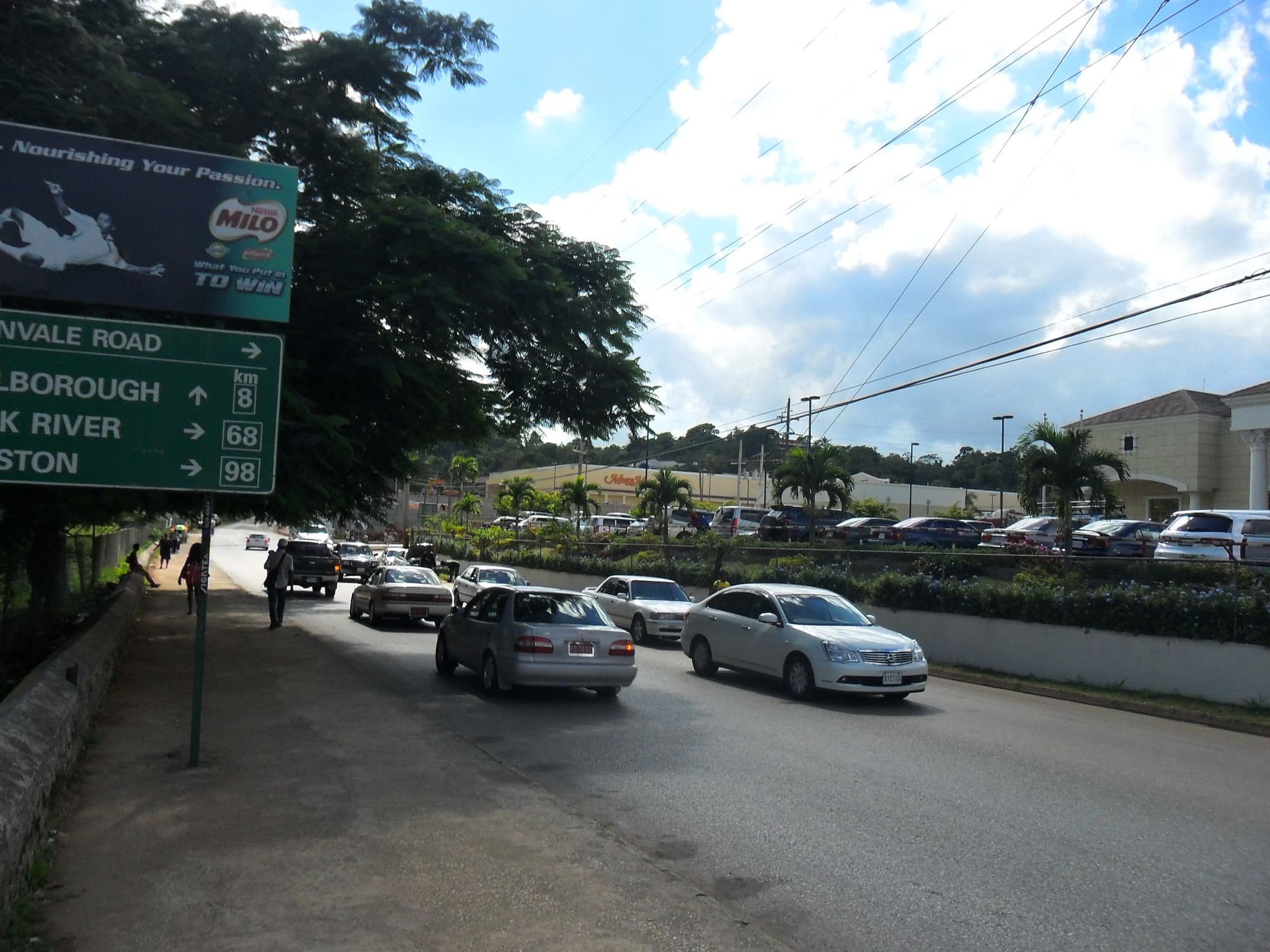 Vehicles and roadside businesses on Perth Road in Mandeville, Jamaica