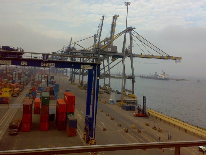 Container stacks and cargo cranes beside the water at Chennai Container Terminal in India