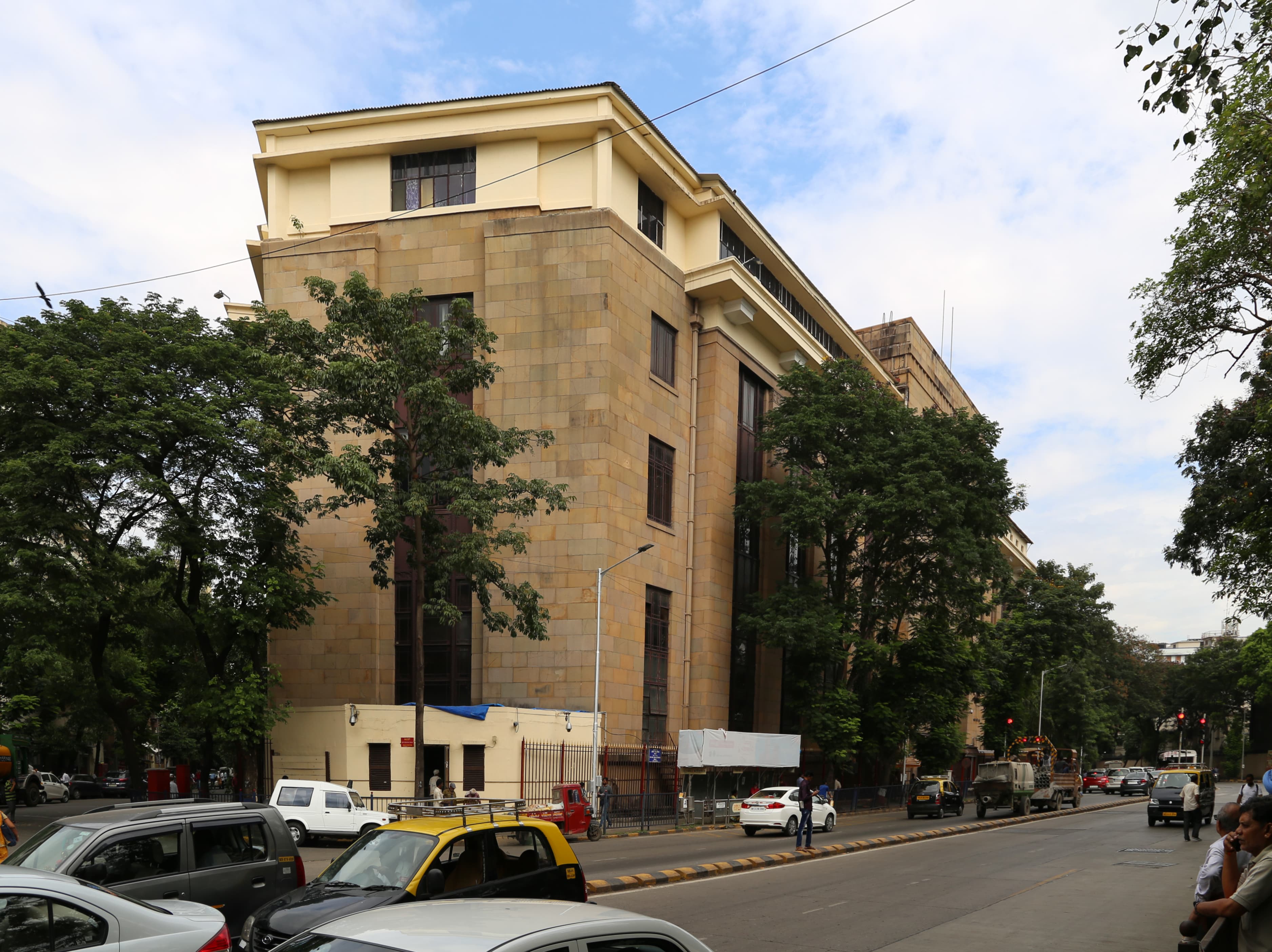 Reserve Bank of India building beside a tree-lined street in Mumbai
